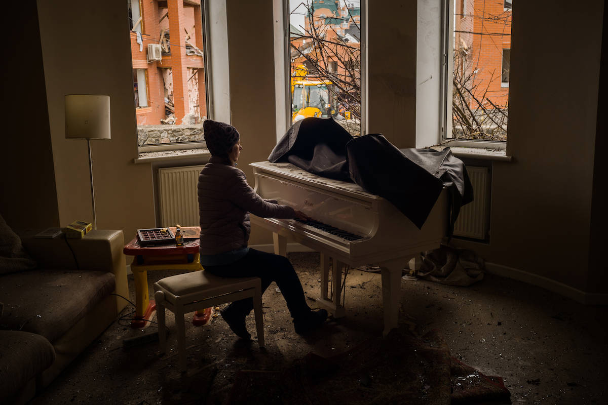 Zdjęcie Roku Grand Press Photo 2022: Irina Maniukina gra na fortepianie w swoim dopiero co zbombardowanym przez Rosjan domu.. Fot.Wojciech Grzędziński dla „The Washington Post”
