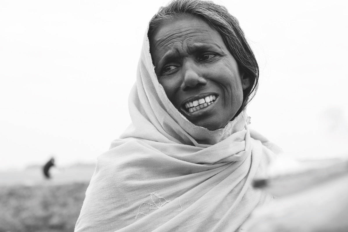WYDARZENIA: Marcin Zaborowski, „National Geographic Polska”. Bangladesz. Droga Teknaf-Shoh Porir Dwip. Kobieta stoi przy namiocie straży granicznej, w którym wydawane są przepustki do punktu tranzytowego. Tej nocy przypłynęła łodzią do zachodniego wybrzeża wyspy Shoh Porir Dwip wraz z Rohingjami, którzy uciekli z Birmy do Bangladeszu. Kobieta płacze, bo choć po kilku godzinach czekania otrzymała w końcu przepustkę do dalszej drogi, została rozdzielona z mieszkańcami swojej wioski. 29 października 2017